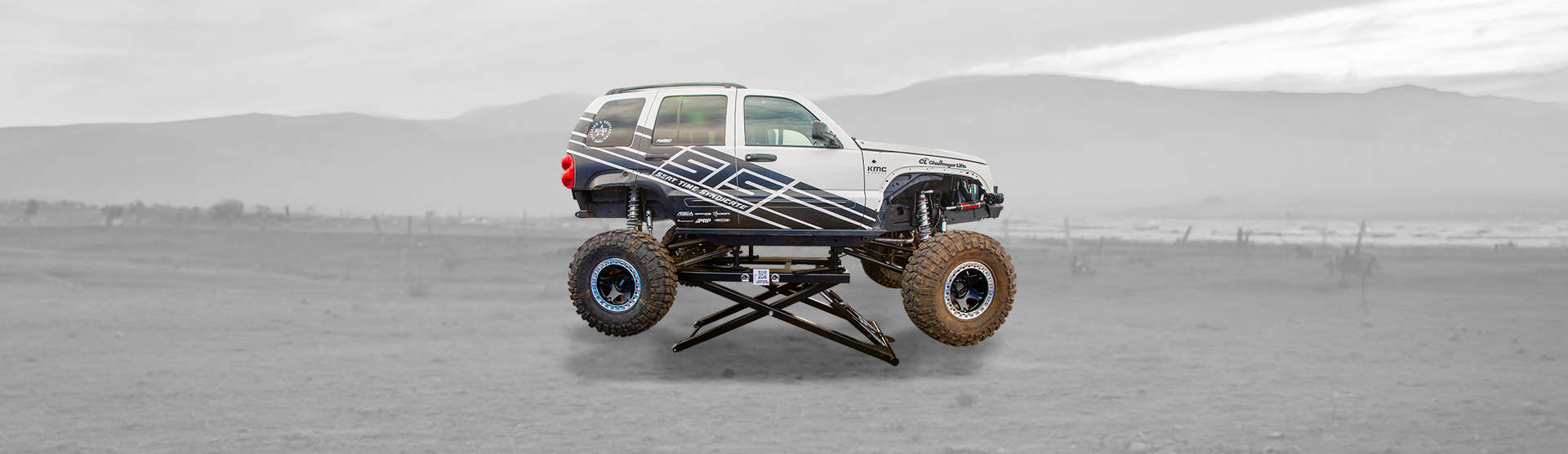 An off-road vehicle lifted off the ground on a Challenger Lifts MR6